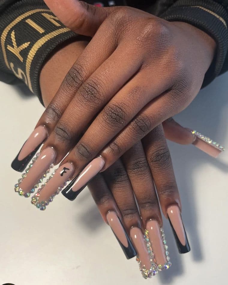 Long coffin nails, nude with black side french, crystal edging and a painted initial