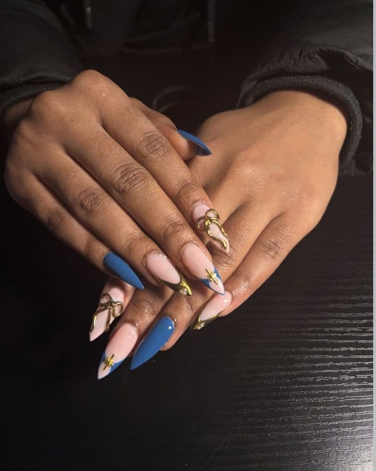 Stiletto nails in matte blue with 3D gold bows and gold star charms