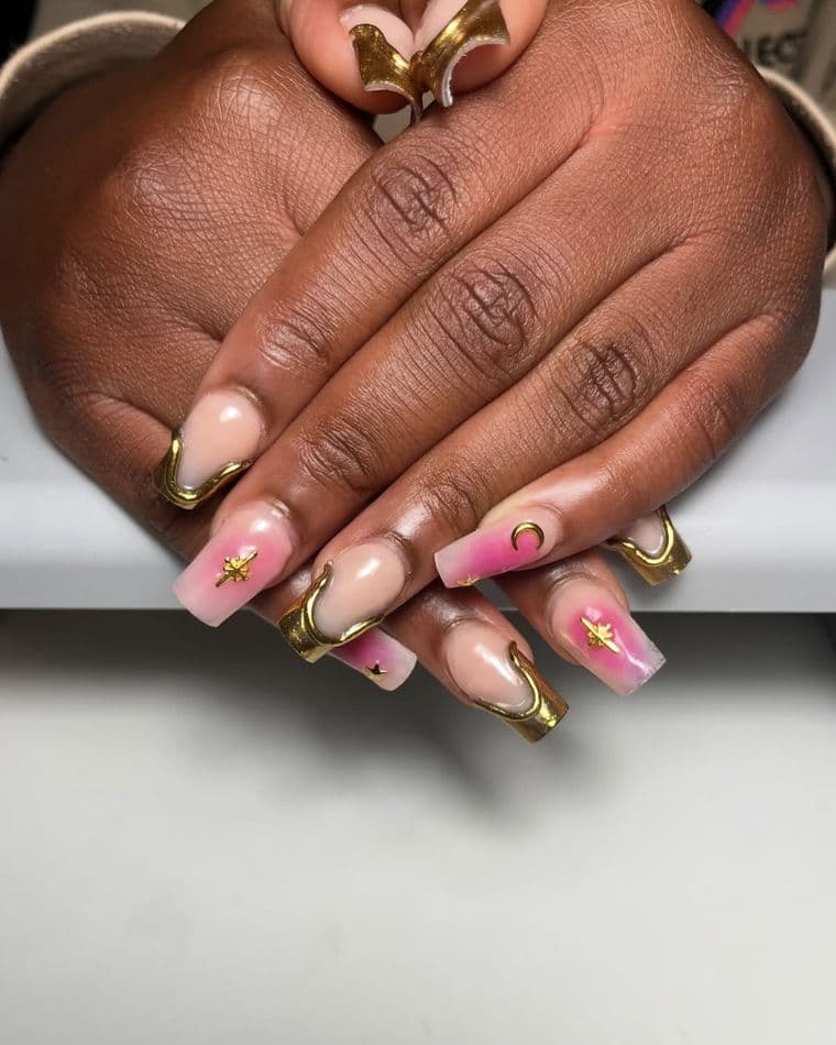 Coffin nails with gold chrome french tips, pink aura fade and gold star charms