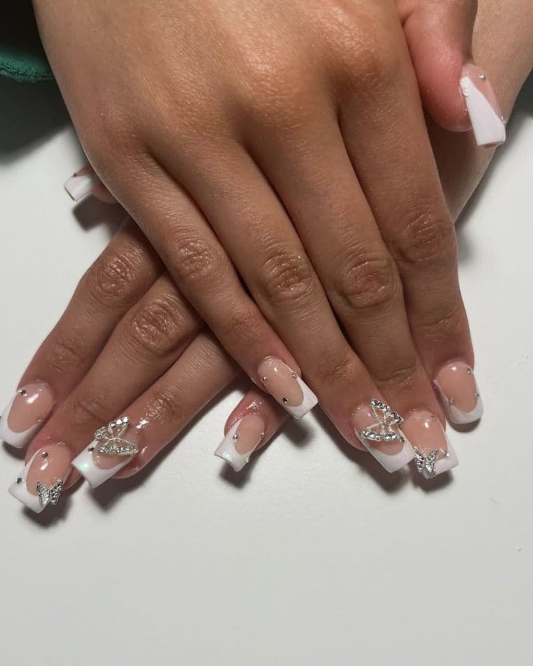 Square nails with clean white french tips and crystal butterfly charms