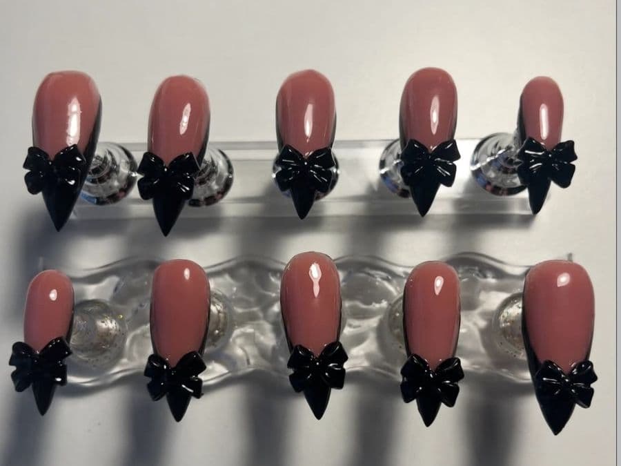 Full press-on set of ten almond nails in dusty rose with 3D black bows